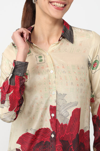 Woman wearing a cream shirt with red floral patterns on a white background