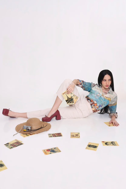Person sitting on a white floor with scattered items, including a hat and cards.