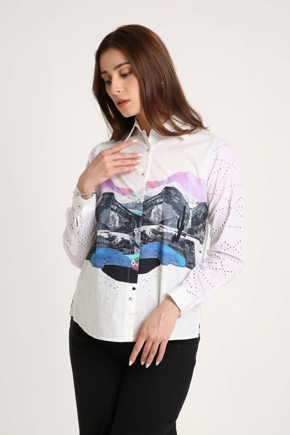 Woman wearing a white shirt with colourful abstract design on a plain background