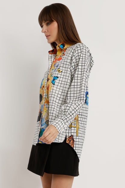 Woman wearing a colorful floral blouse with a checkered pattern over it on a white background