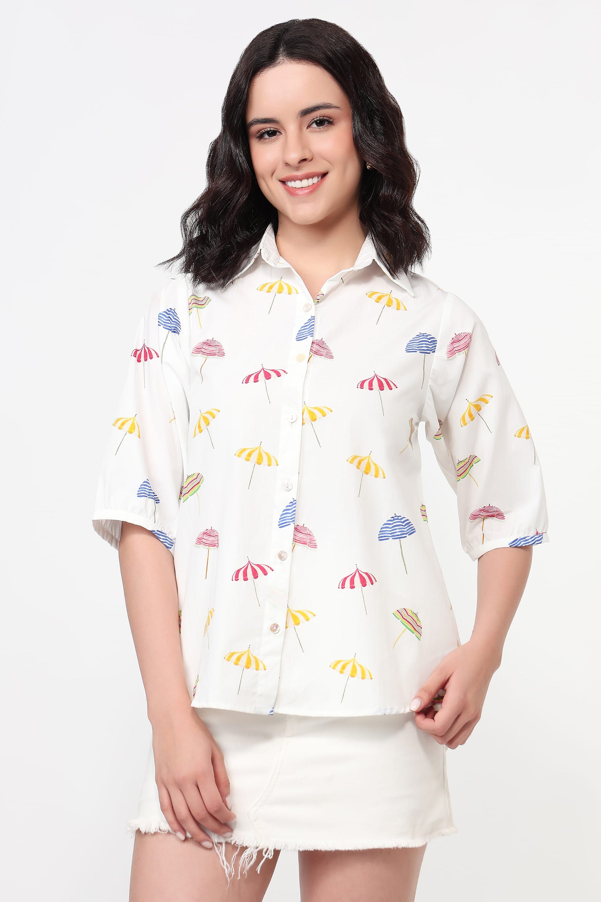 Woman wearing a white shirt with colorful patterns on a white background