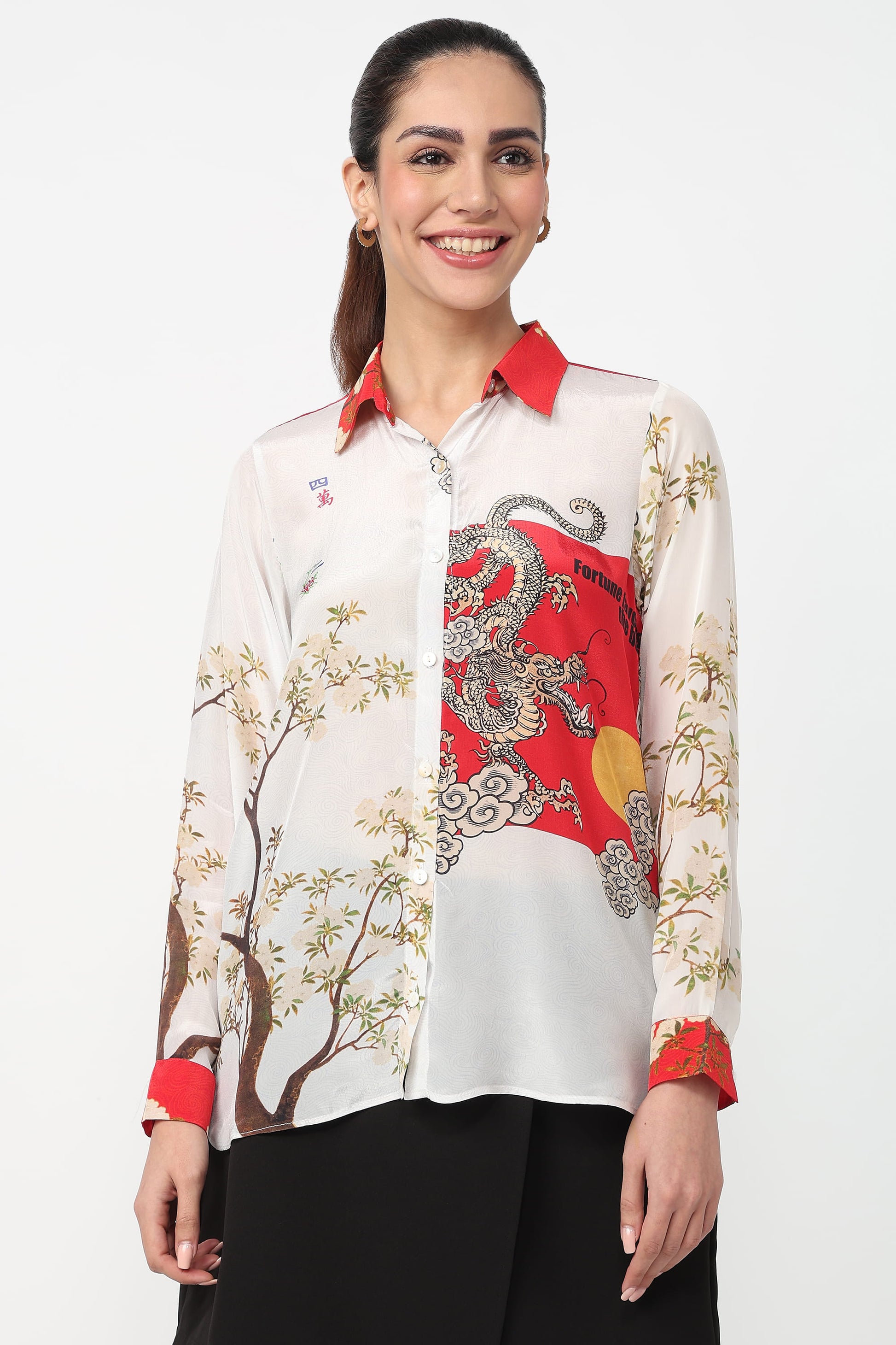 Woman wearing a patterned shirt with red and black design on a white background