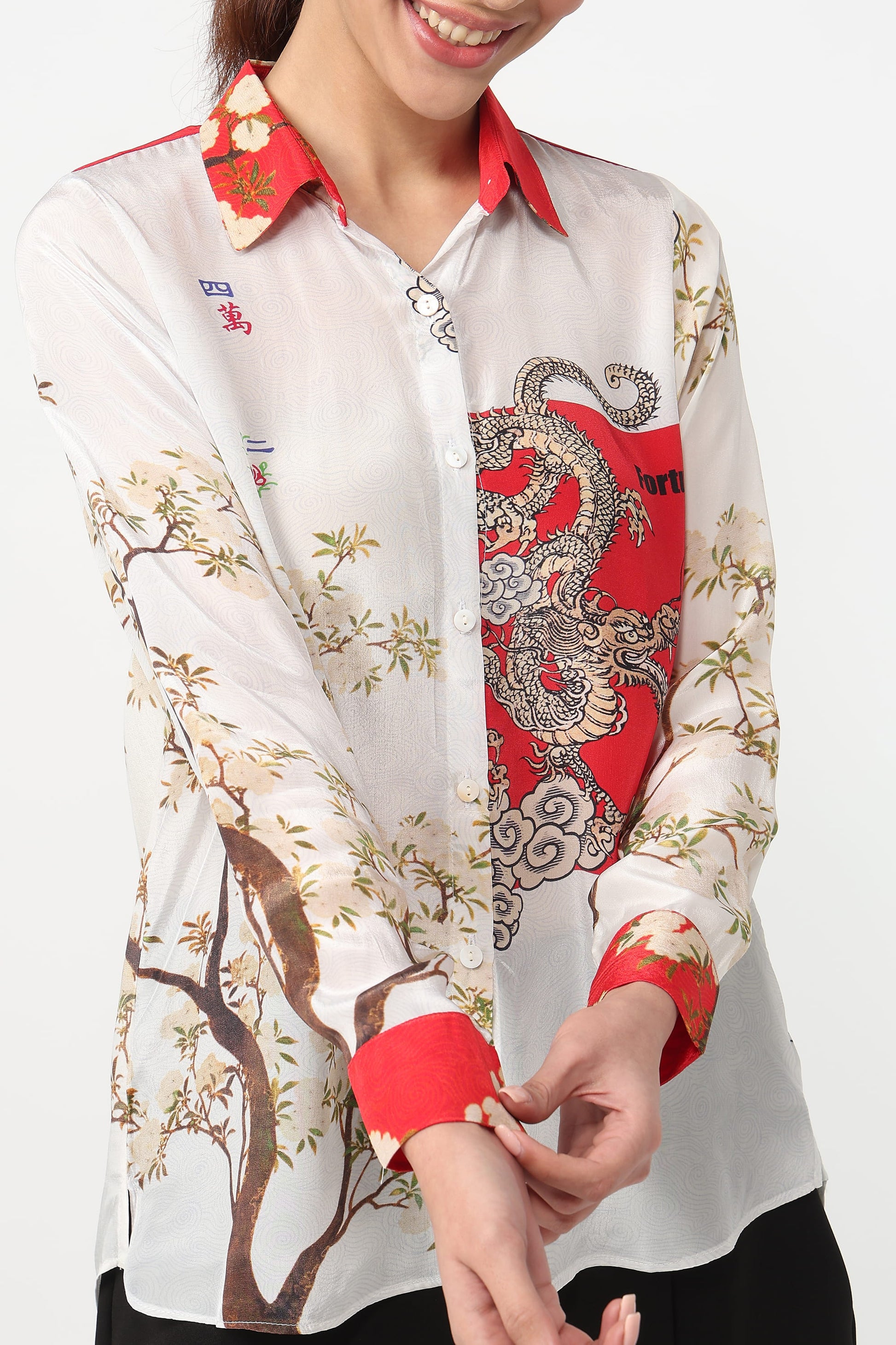 Woman wearing a white shirt with red and floral patterns on a white background