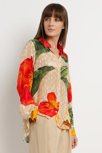 Woman wearing a colorful floral blouse with a plain background