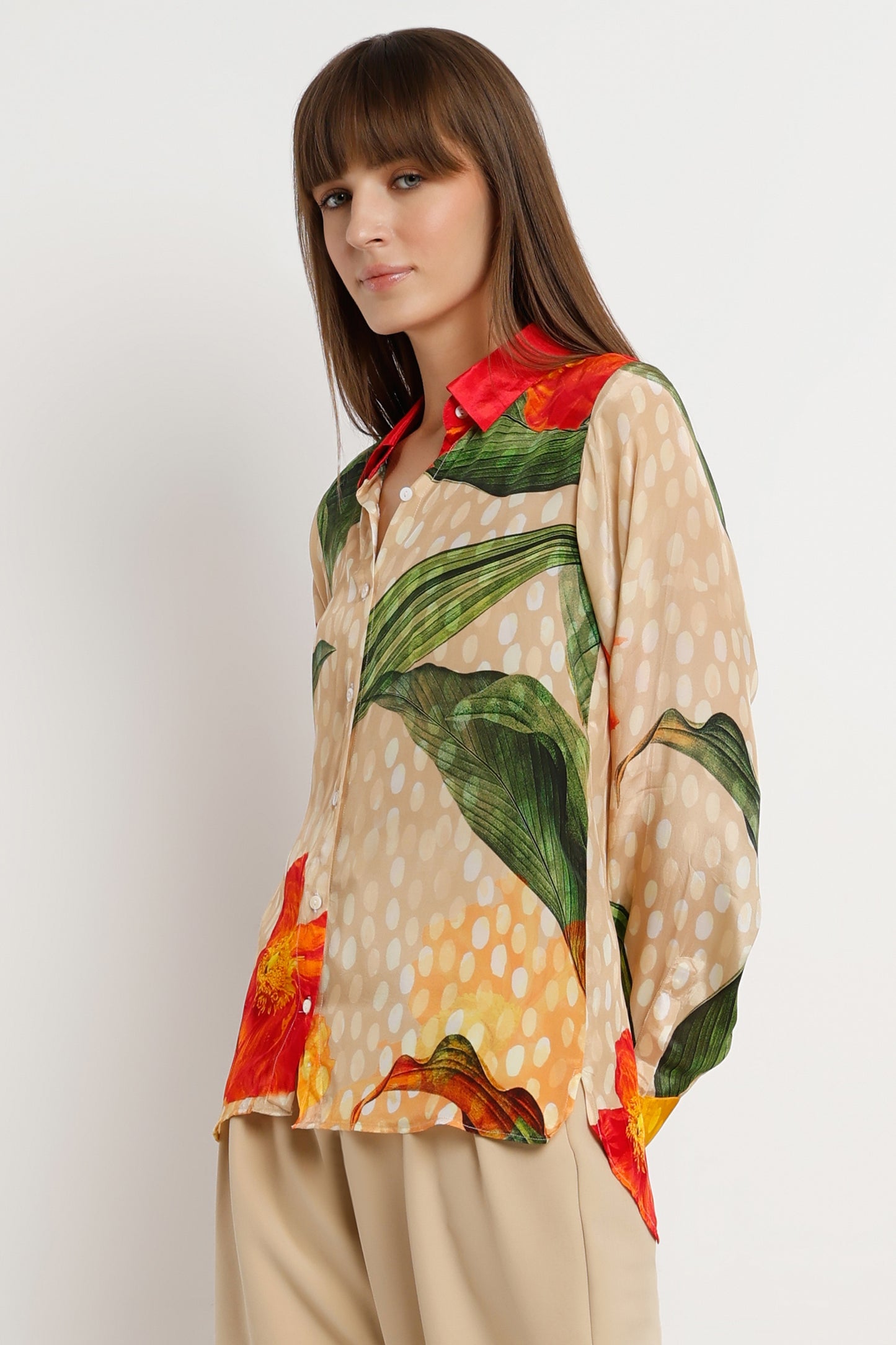 Woman wearing a colorful floral blouse with a plain background