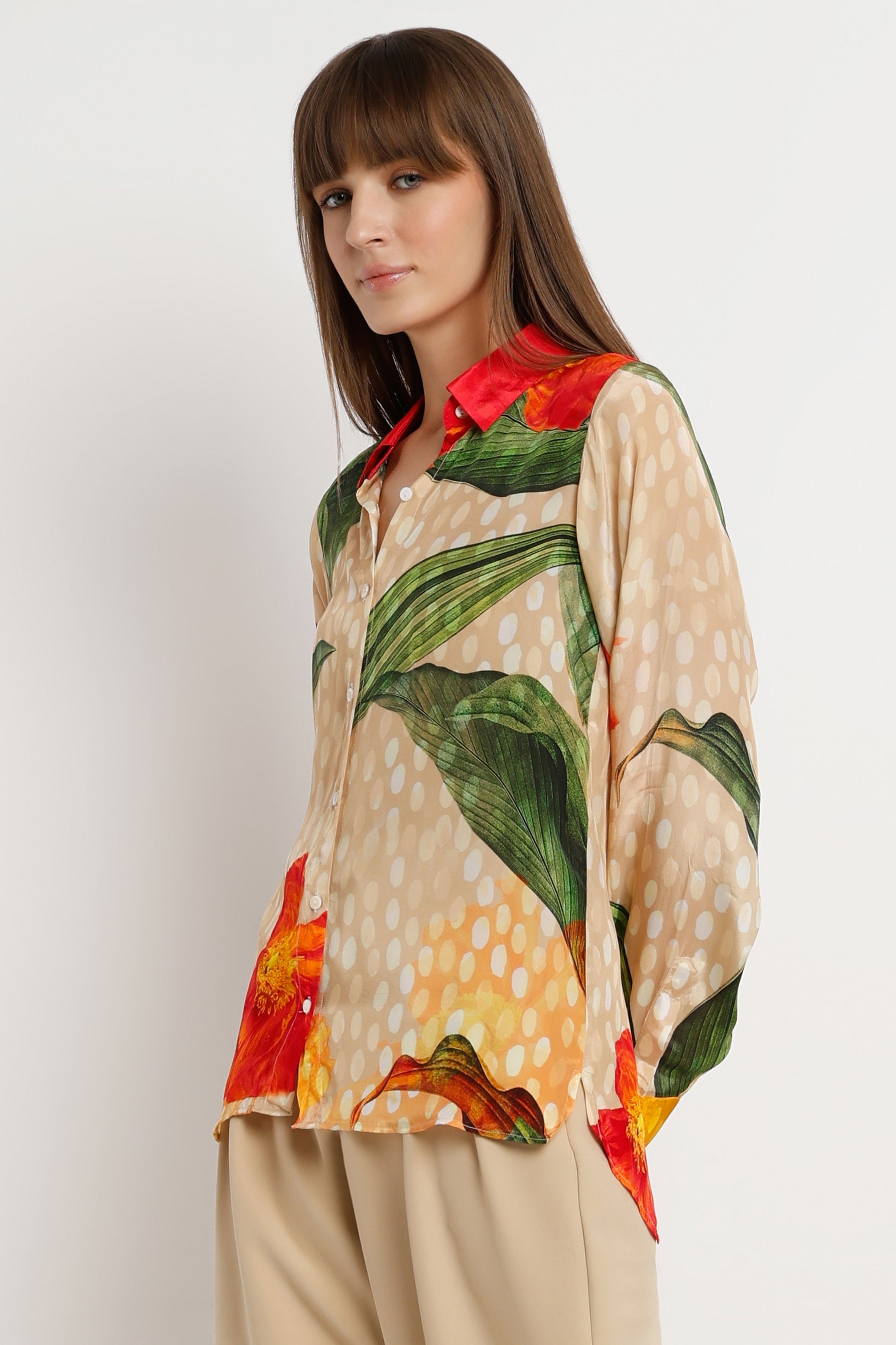 Woman wearing a colorful floral blouse with a plain background