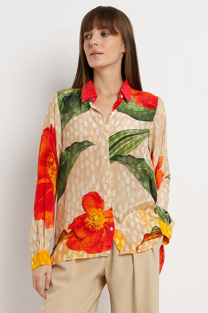 Woman wearing a colorful floral blouse with a plain background