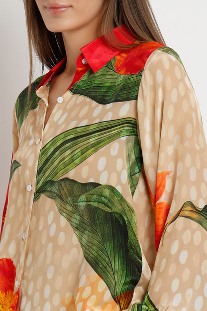 Close-up of a person wearing a shirt with a leaf pattern and red collar.