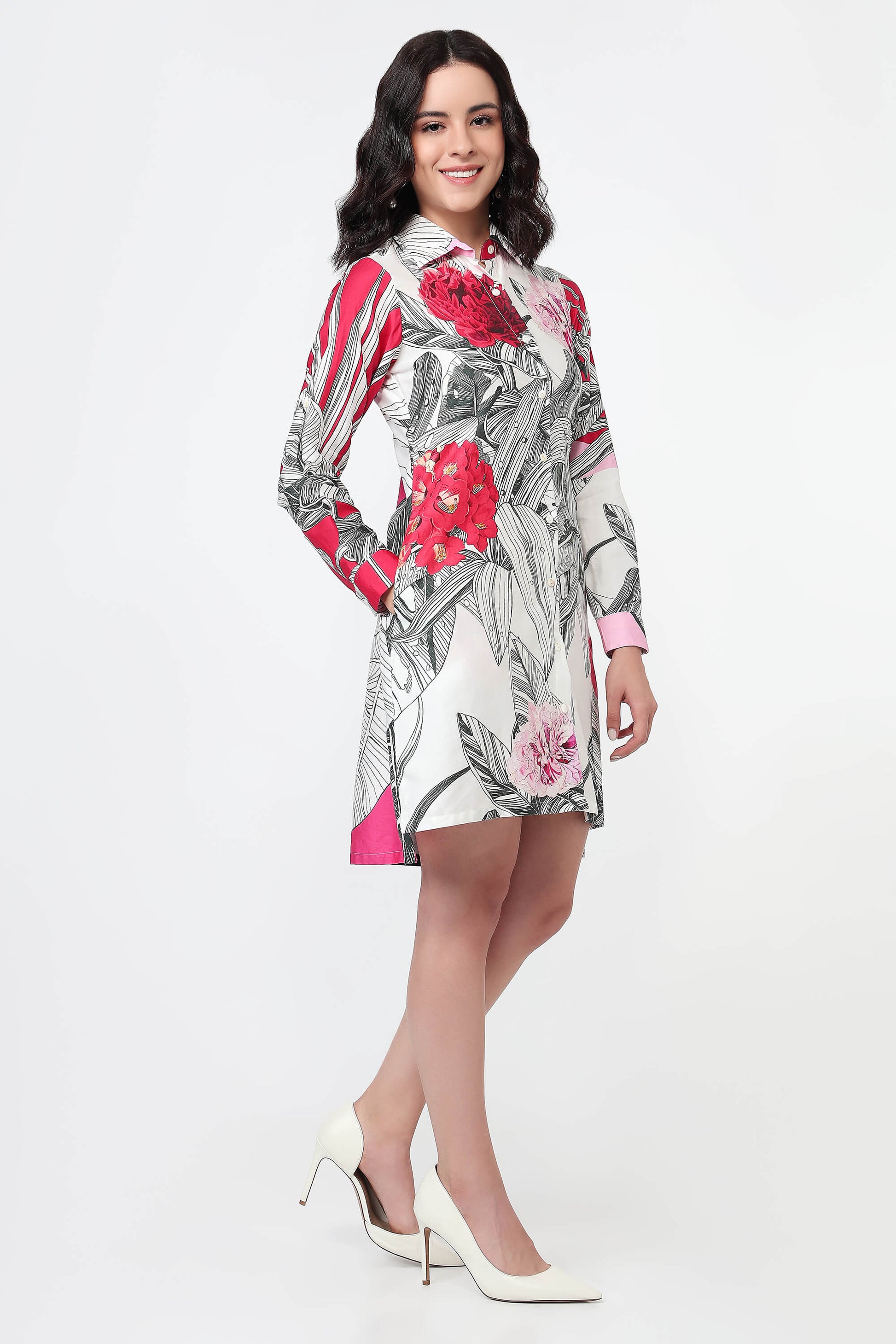 Woman wearing a pink dress with abstract patterns on a white background