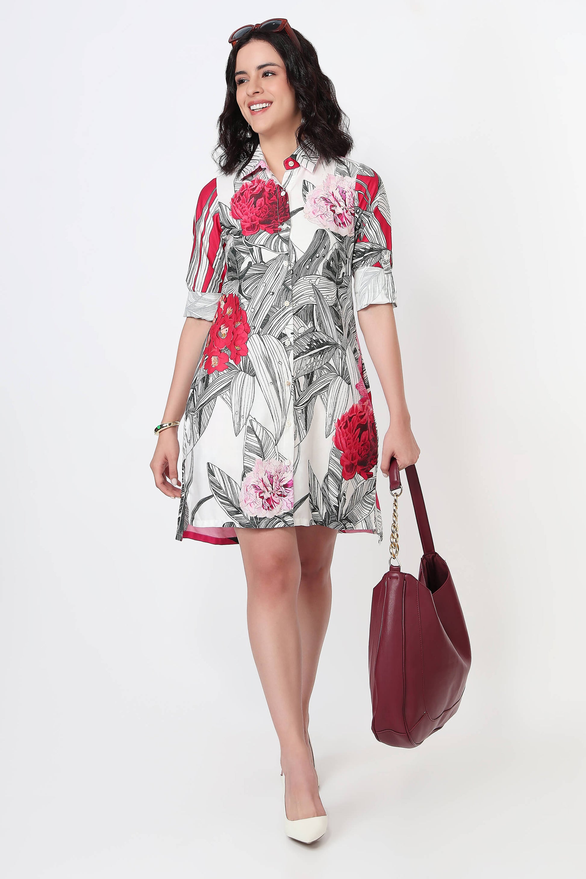 Woman wearing a pink dress with abstract patterns on a white background