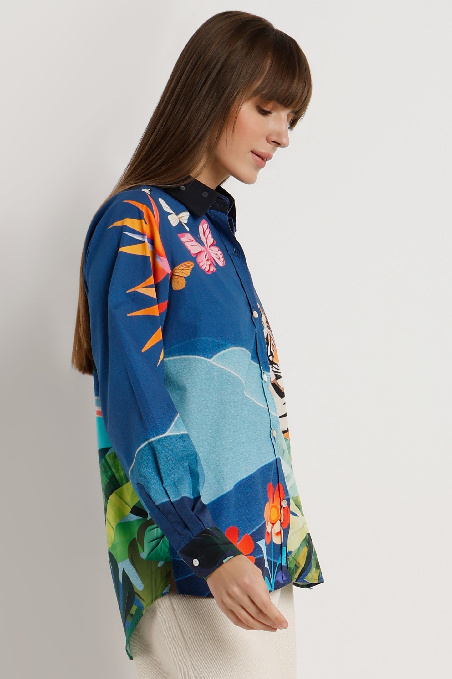 Woman wearing a colorful floral blouse against a plain background