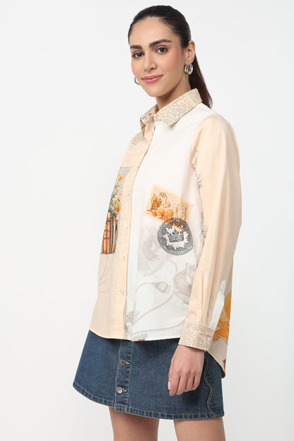 Woman wearing a cream shirt with a graphic design and a denim skirt on a white background