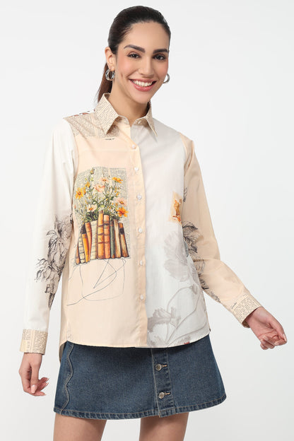Woman wearing a cream shirt with floral and book design and a denim skirt on a white background