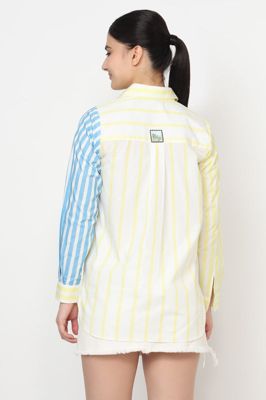 Woman wearing a striped shirt with blue and yellow sleeves on a white background
