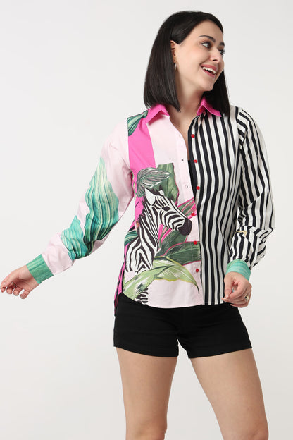 Woman wearing a colorful shirt with zebra print and black shorts on a white background