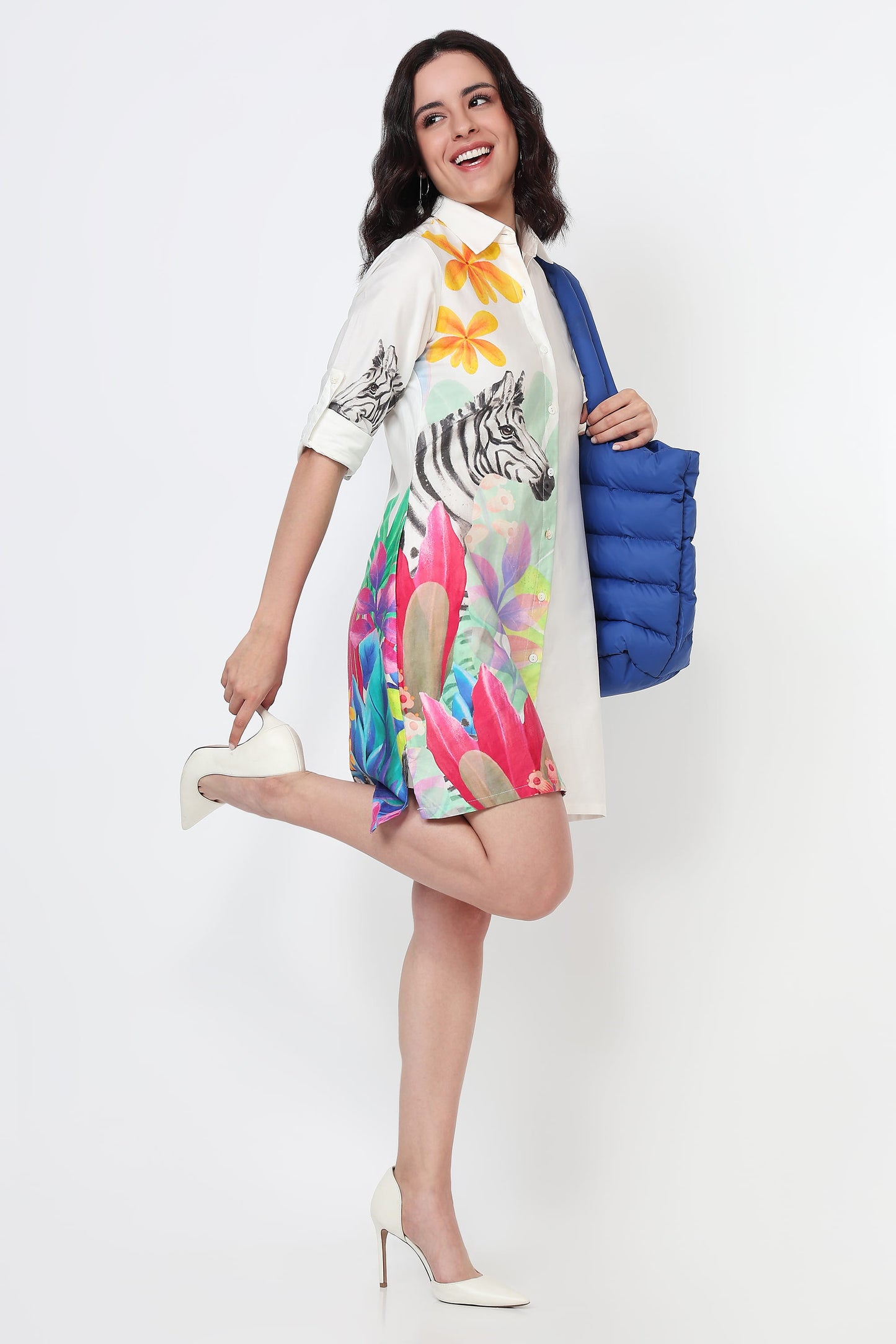 Woman wearing a white shirt dress with colourful zebra and floral design on a white background