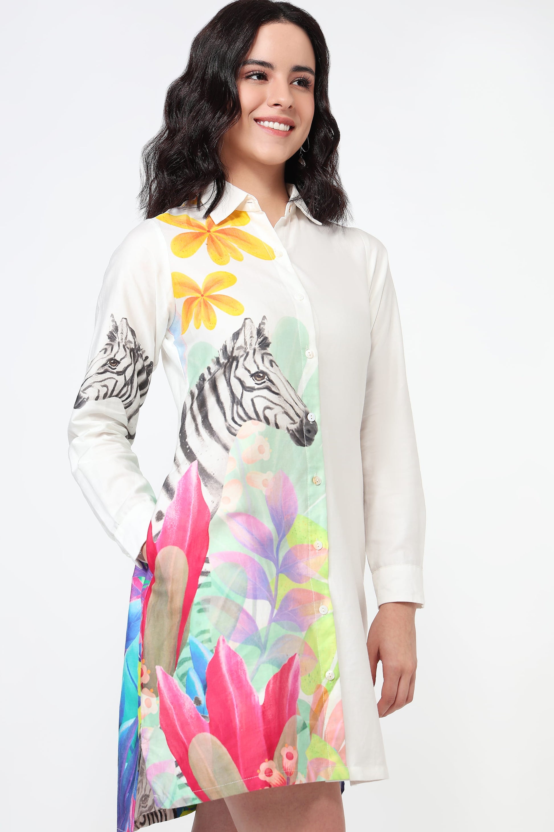 Woman wearing a white shirt dress with colourful zebra and floral design on a white background