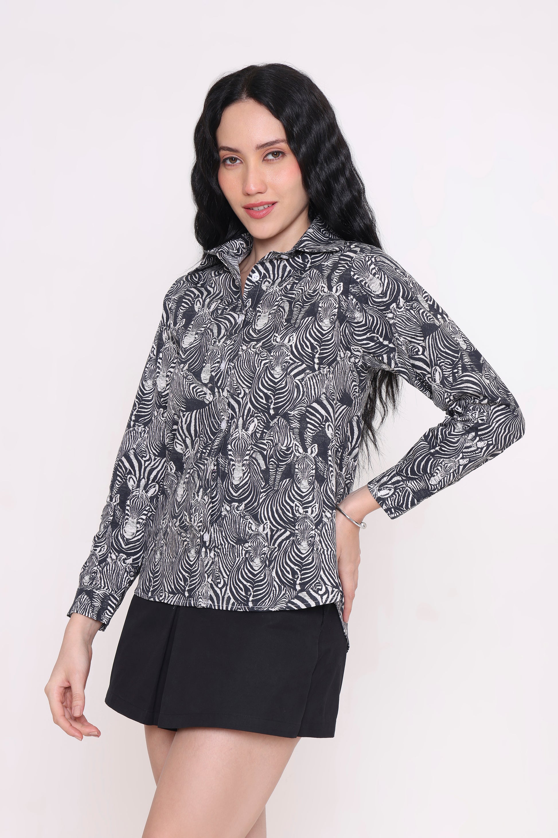 Woman wearing a patterned blouse and black skirt on a white background